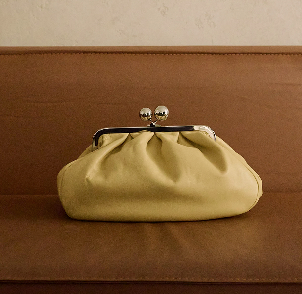 Green handbag displayed on a chair